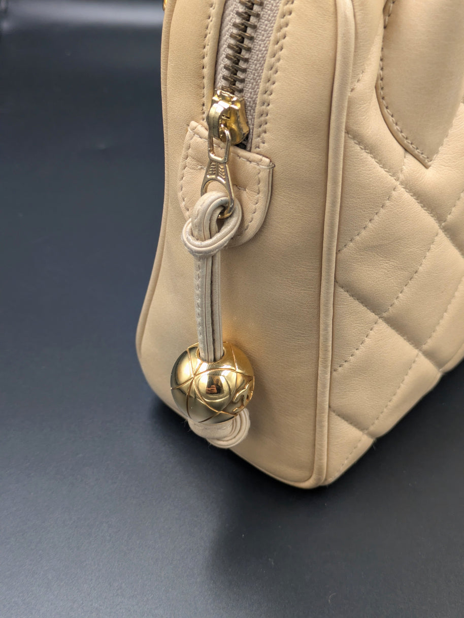 Zip du sac Chanel vintage beige terminé par une boule dorée, vue de côté