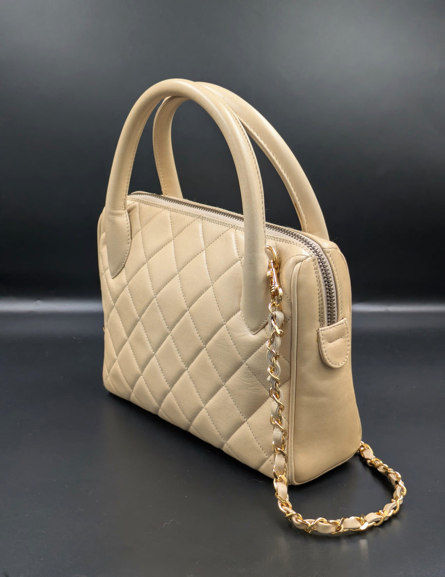 Sac Chanel vintage beige de profil avec chaîne dorée entrelacée de cuir