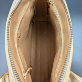 Intérieur du sac Chanel vintage beige, doublure cuir et poches zippées