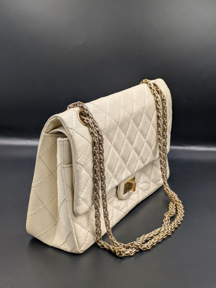Sac Chanel 2.55 écru de profil, soufflet et double chaîne dorée