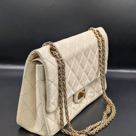 Sac Chanel 2.55 écru de profil, soufflet et double chaîne dorée