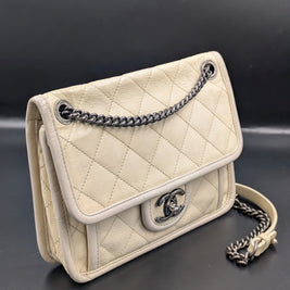 Chanel French Riviera Flap beige vu de trois quarts, rabat matelassé et liseré clair