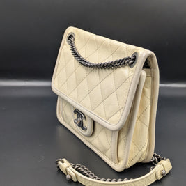 Chanel French Riviera Flap beige de profil, bandoulière chaîne et cuir
