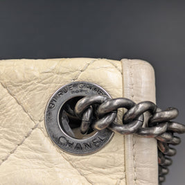 Gros plan sur l’œillet gravé CHANEL et la chaîne ruthénium du French Riviera Flap